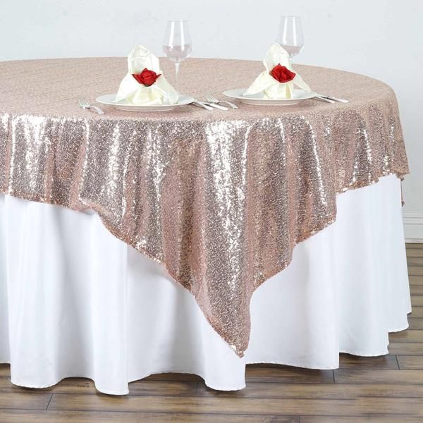 the table is covered with sequins and has two wine glasses on top of it