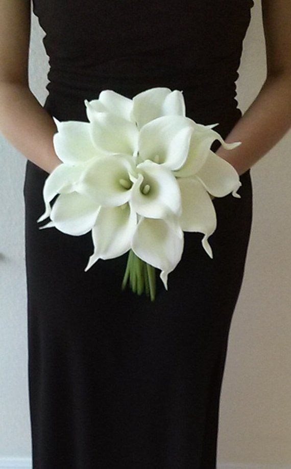 a woman in a black dress holding a white flower