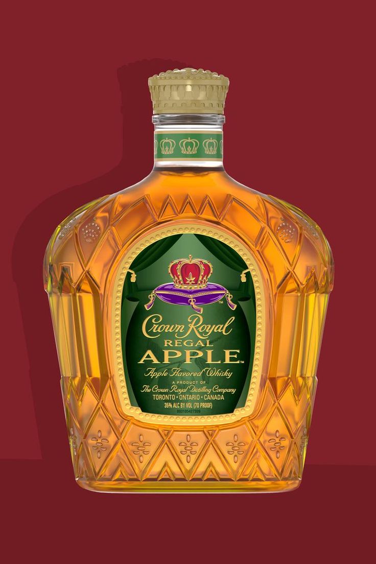 a bottle of crown royal regal apple liqueur sitting on a red tablecloth