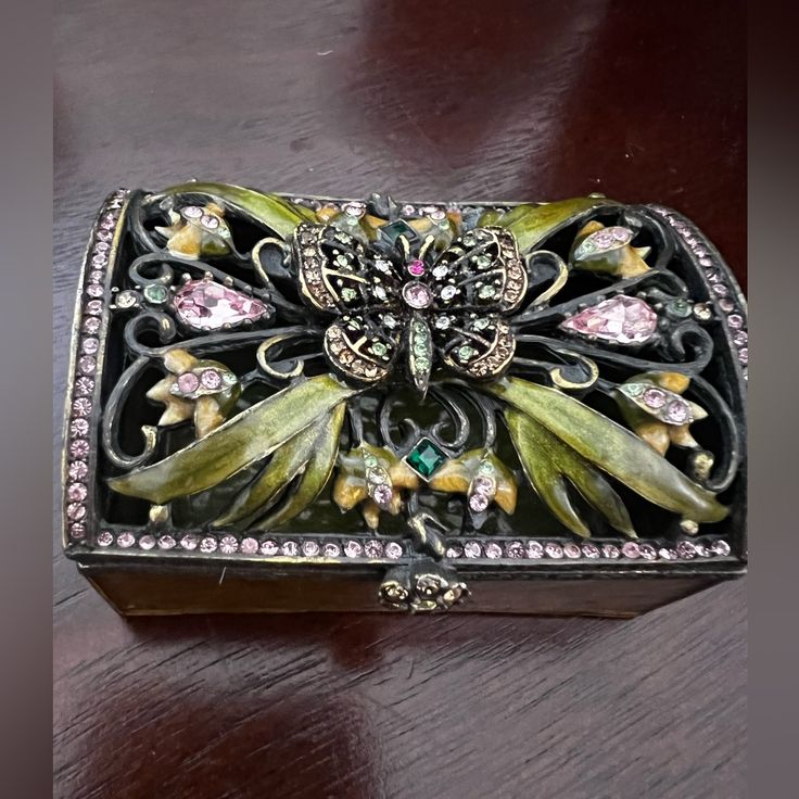 an ornately decorated box sitting on top of a wooden table