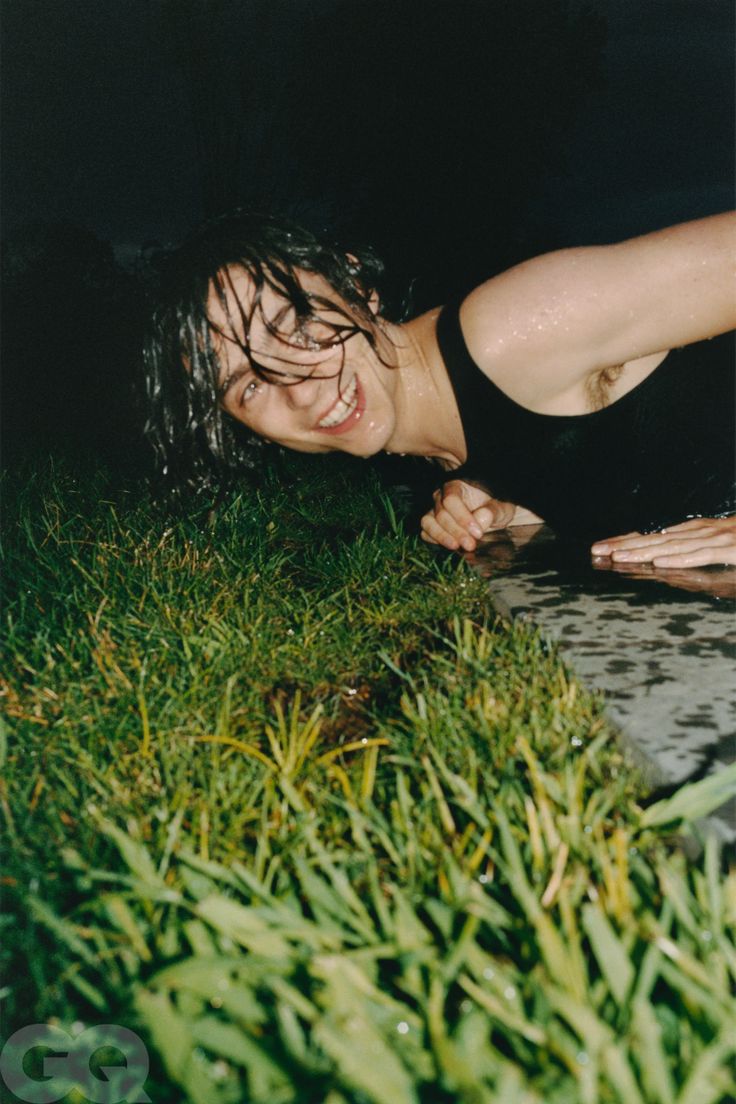 a woman laying in the grass with her mouth open