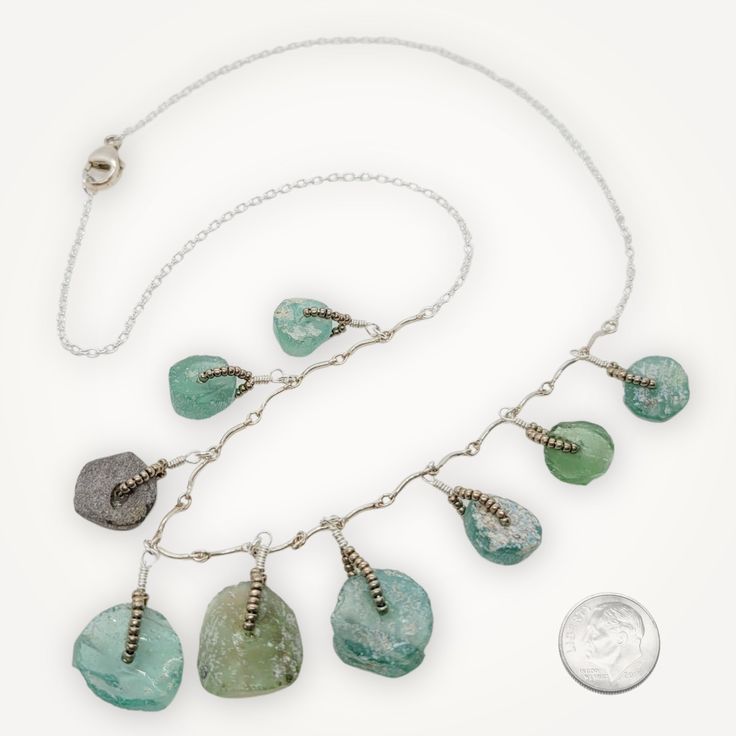 This 18" sterling silver necklace showcases intricately woven pewter seed beads and Roman glass medallions, an ancient material excavated from Mediterranean sites that dates back to roughly 100 BCE. This glass has developed a unique texture and patina due to its age, providing a unique and timeless look. The lobster closure allows for easy wearing of the necklace. Packaged with a Roman Glass info card. Silver Wire-wrapped Necklace With Recycled Glass, Silver Wire Wrapped Necklace With Recycled Glass, Wire Wrapped Silver Recycled Glass Jewelry, Wire Wrapped Silver Jewelry With Recycled Glass, Handmade Silver Recycled Glass Necklace, Handmade Silver Necklace With Recycled Glass, Unique Silver Jewelry With Recycled Glass, Nickel-free Round Recycled Glass Jewelry, Nickel Free Silver Necklace Of Recycled Glass