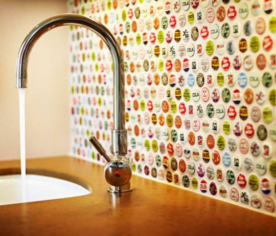 a faucet that is next to a sink in a room with colorful wallpaper