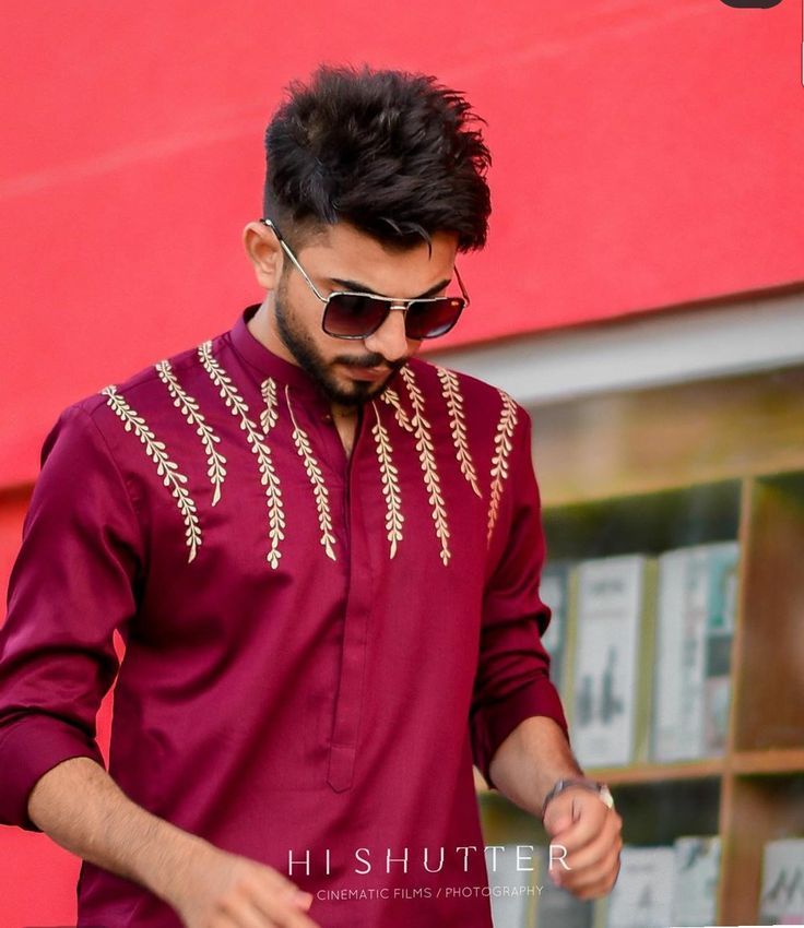 a man wearing a maroon shirt and sunglasses