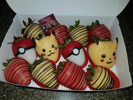 chocolate covered strawberries in a box with pokemon figurines on the top one