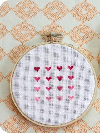 a cross stitch pattern with hearts on it and a pair of scissors next to it