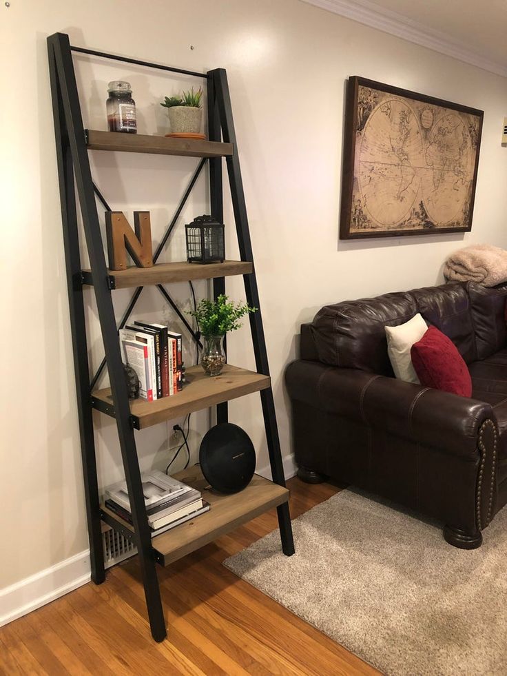 a living room with a brown leather couch and book shelf next to a wooden floor