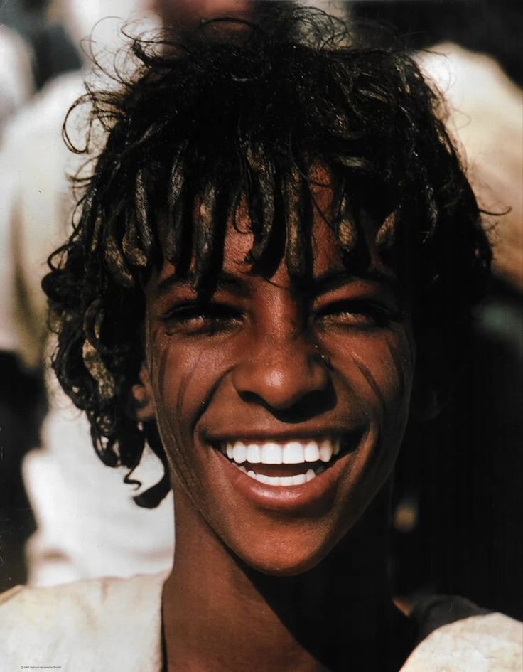 a man with dreadlocks smiles for the camera