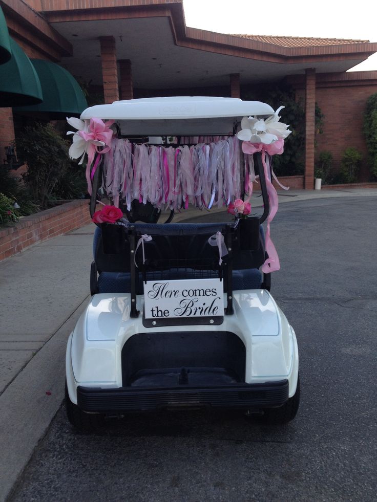 a golf cart decorated with pink and white streamers