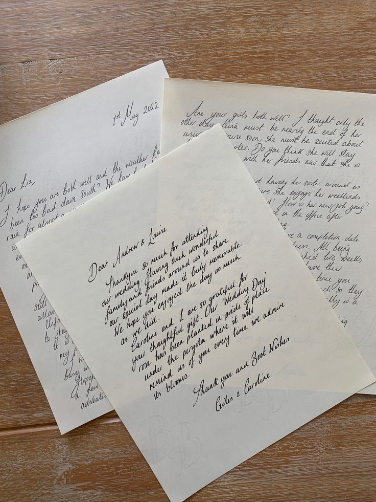 three handwritten letters sitting on top of a wooden table next to an envelope with writing on it