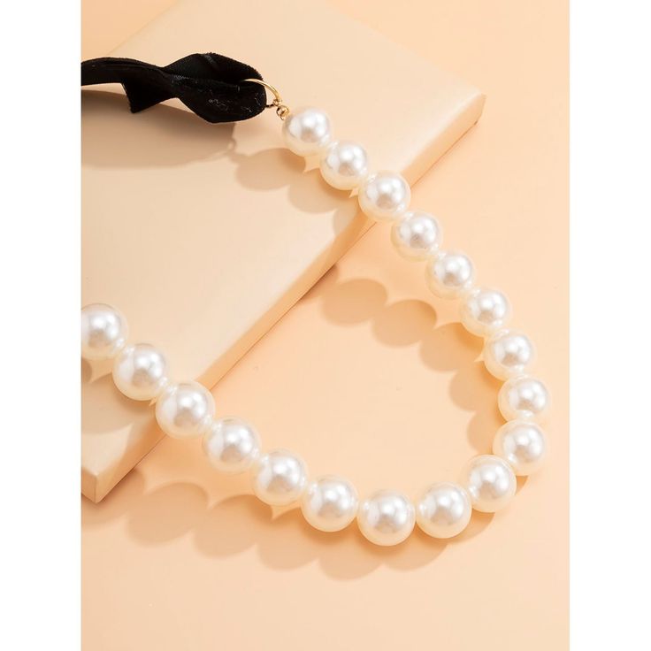 This unique faux pearl necklace is an eye catching beauty that will staple your elegant style. Perfect to complete a glamorous look. Features: Faux Pearl with Velvet self tie. Size: Line of pearls - 21.5", Velvet tie 7.75" Color: Ivory/Black Chic Adjustable Pearl Necklace, Party Adjustable Beaded Pearl Necklace, Adjustable Pearl Necklace For Party, Adjustable Pearl Choker For Formal Occasions, Formal Adjustable Pearl Chain Choker, Adjustable Pearl Chain Choker For Formal Occasions, Adjustable Pearl Chain Choker For Formal Events, Adjustable Cream Necklace For Party, Cream Pearl Chain Necklace For Party