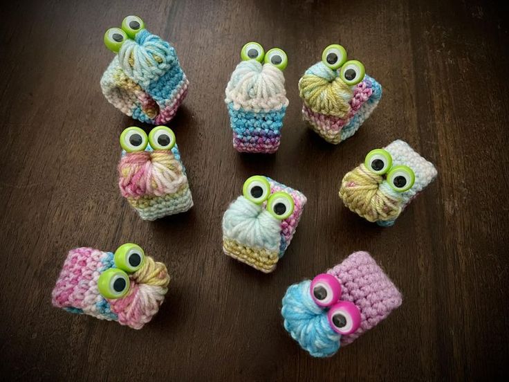 small crocheted owls sitting on top of a wooden table