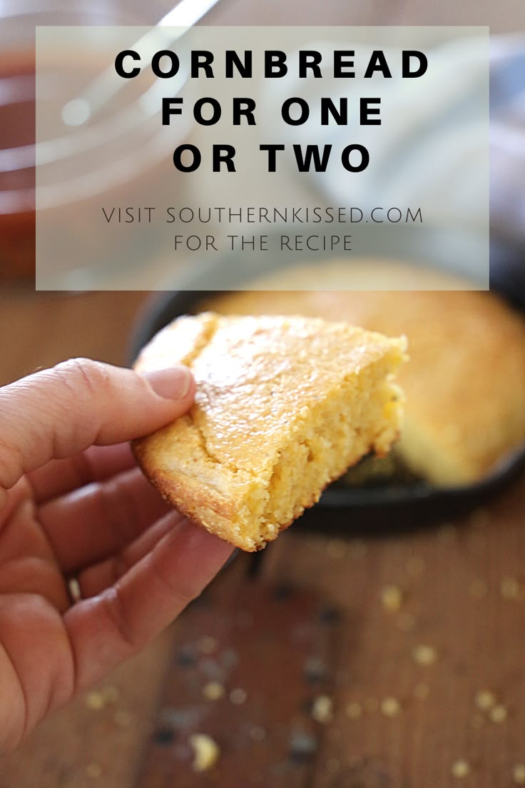 a hand holding a piece of cornbread for one or two