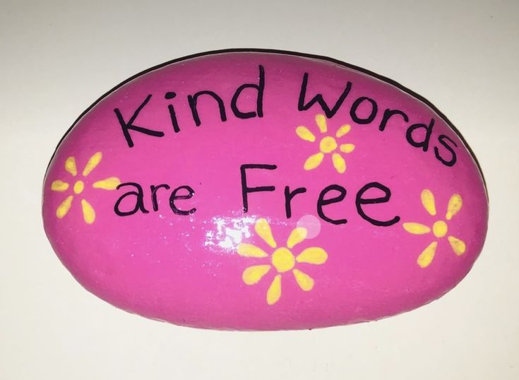 a pink rock that says kind words are free with yellow daisies on the side