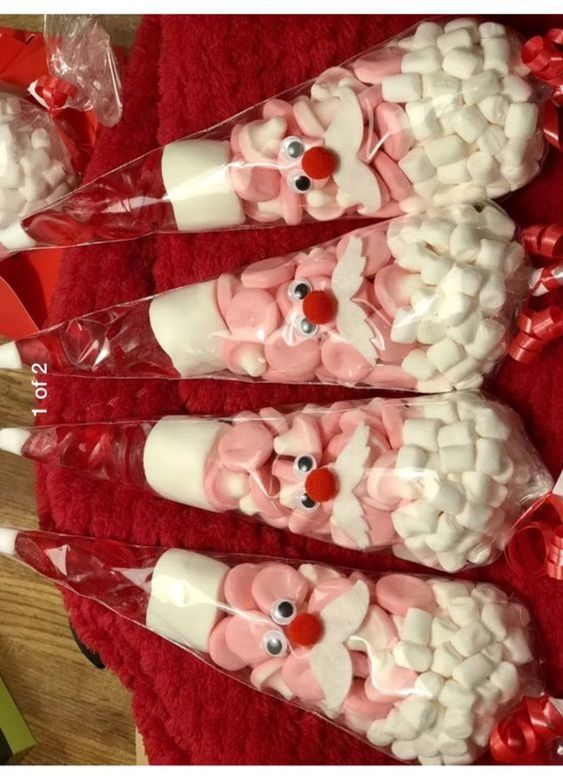 three plastic cups with marshmallows in the shape of santa's helpers