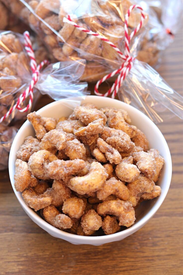 a bowl filled with sugared donuts next to candy canes on a table