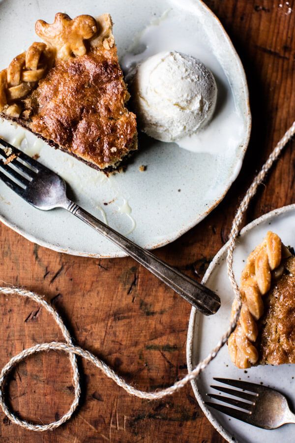 there is a piece of pie on the plate and ice cream in the bowl next to it