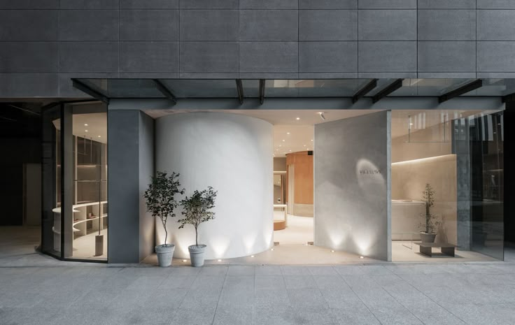 an entrance to a modern building with potted plants