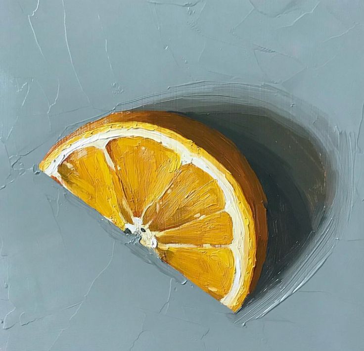 an orange cut in half sitting on top of a gray surface with water around it