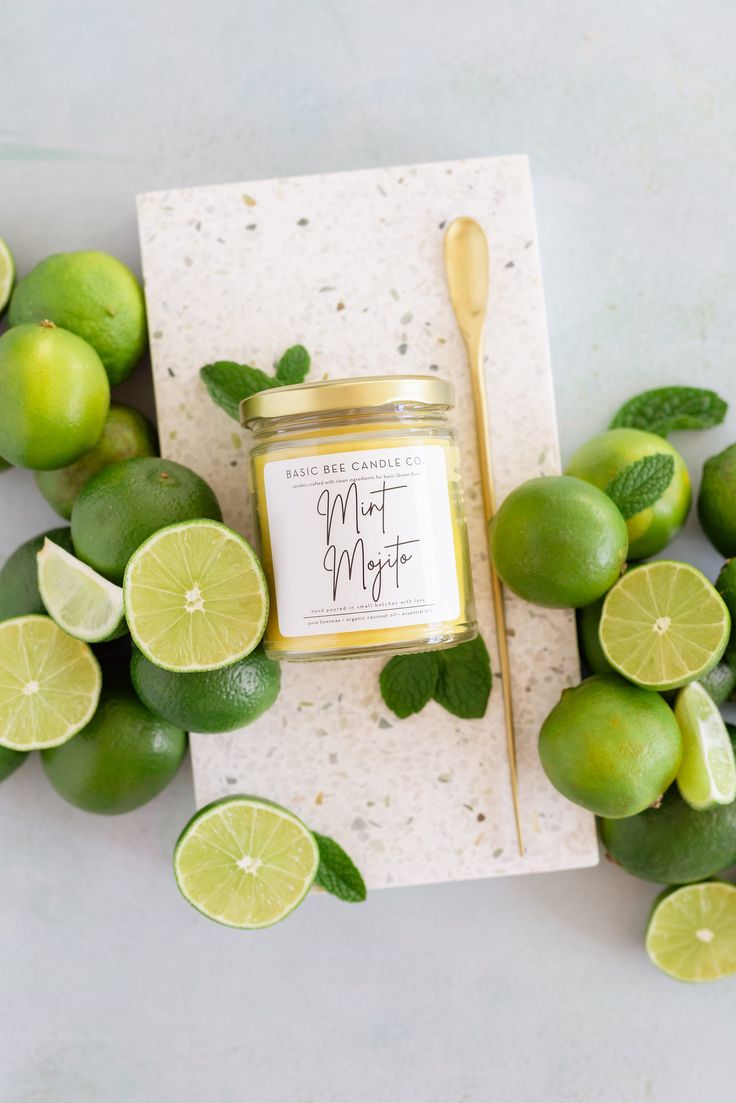 a jar of lemon lime marmalade next to sliced limes and mint leaves