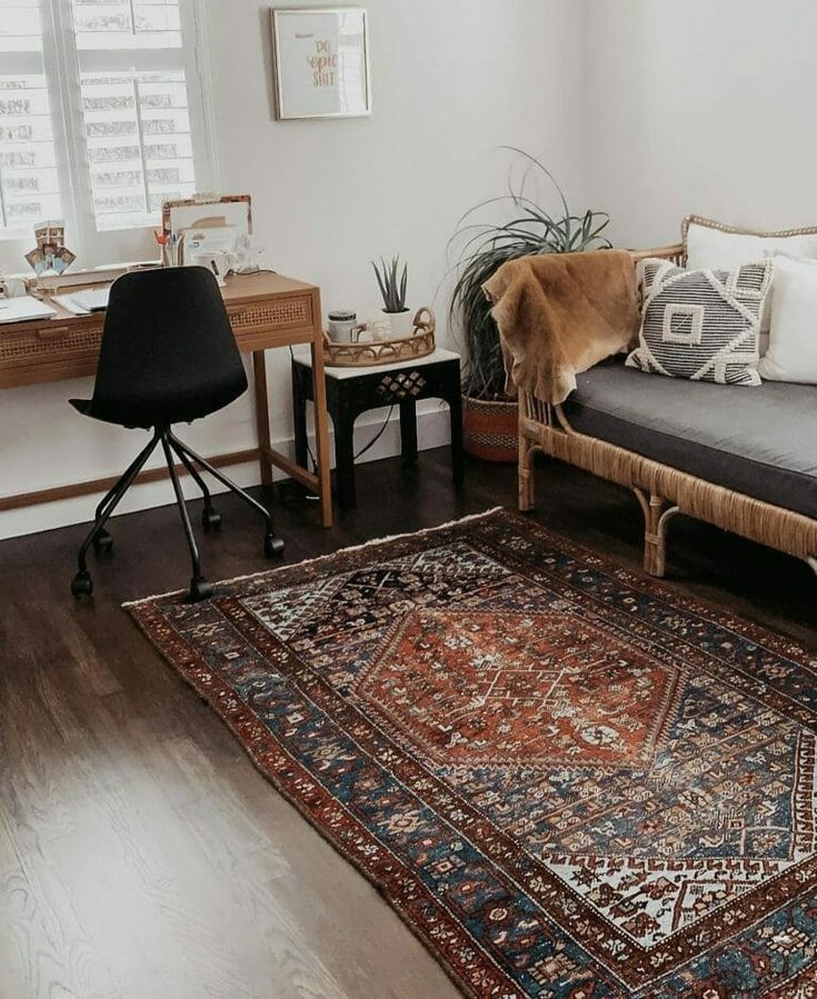 a living room filled with furniture and a rug on top of a hard wood floor