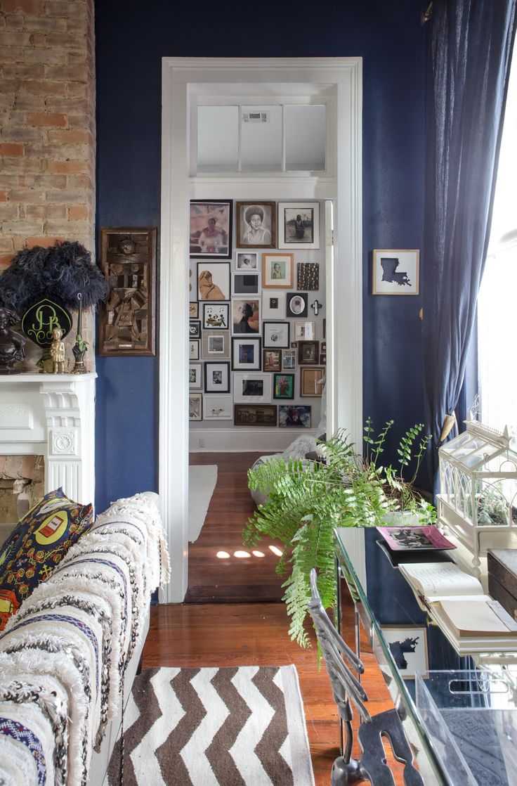 a living room with blue walls and pictures on the wall