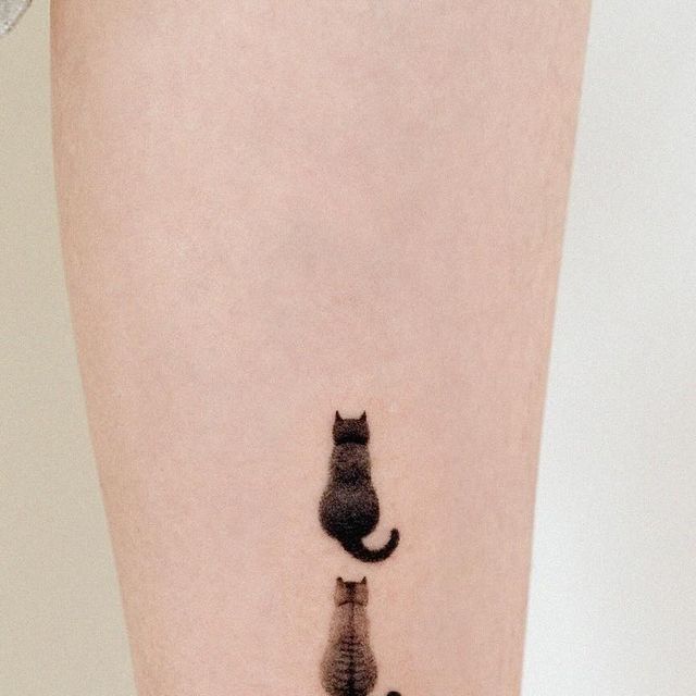 a cat and dog tattoo on the leg