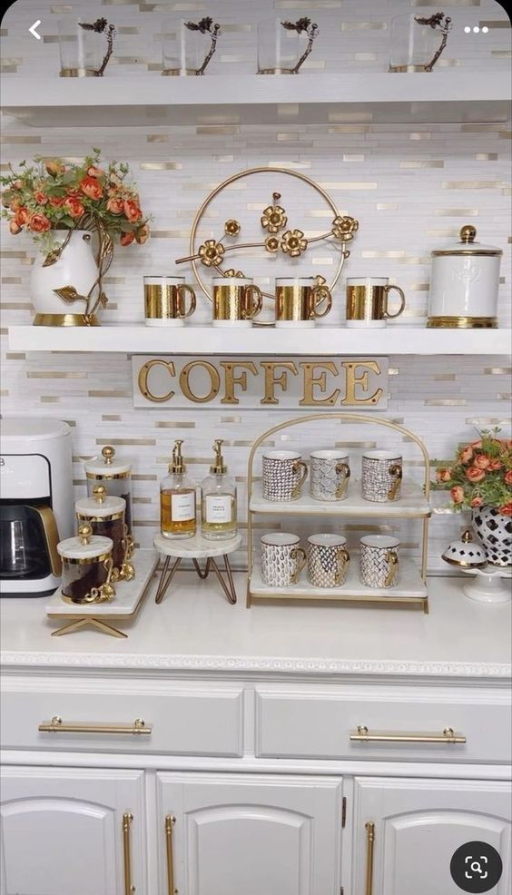 a coffee bar with white cabinets and gold accents