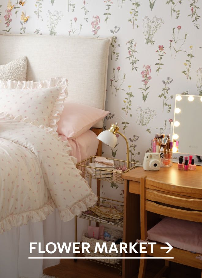 a bedroom with floral wallpaper and white bedding, pink pillows and decorative accessories