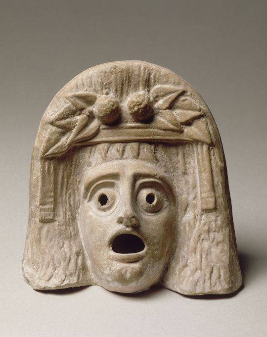 an ancient mask with eyes and headdress