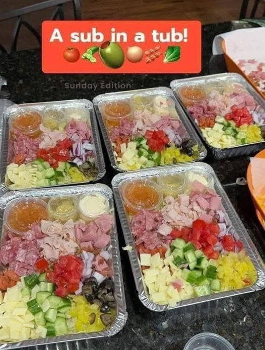 several plastic containers filled with food on top of a black granite counter next to an orange sign that says, a sub in a tub