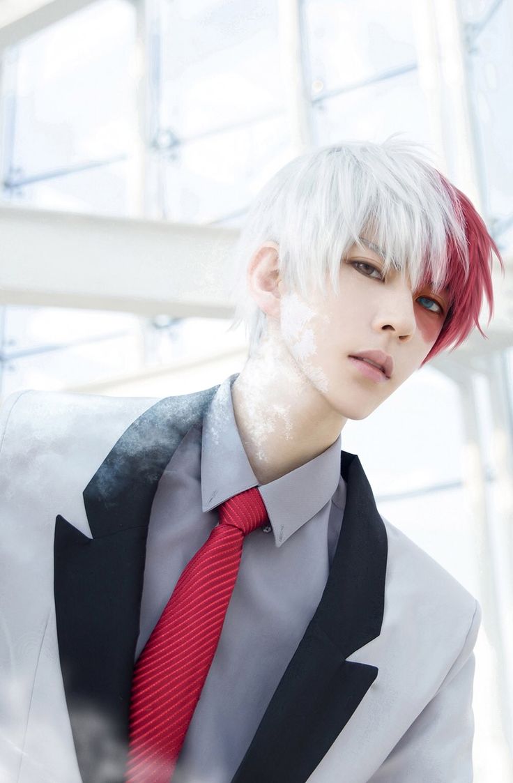 a man with white hair wearing a suit and red tie