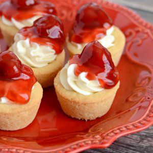 small cupcakes with white frosting and red sauce