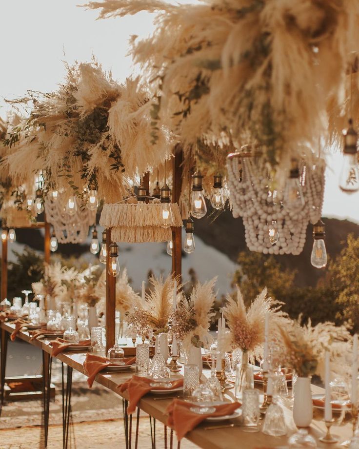 a long table is set up with feathers and chandeliers