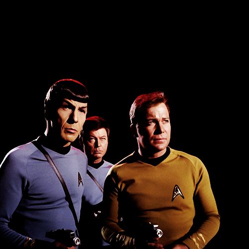 three men in star trek uniforms standing next to each other