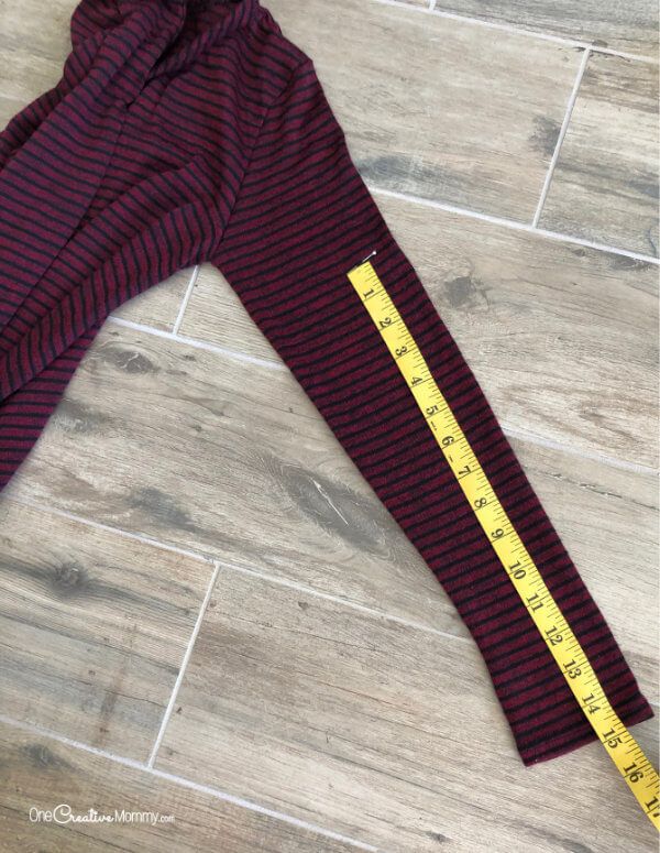 a measuring tape on the side of a maroon and black striped sweatpants with yellow stripes