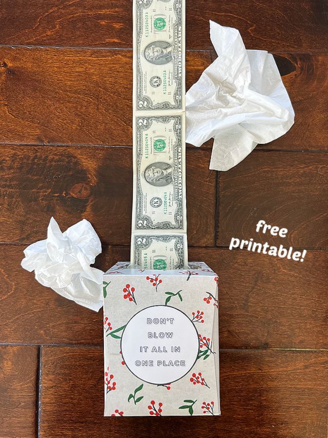 the dollar bill is wrapped in tissue paper and sitting on top of a wooden floor