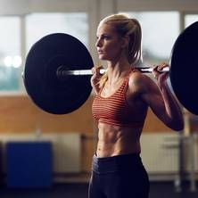 a woman is doing exercises with barbells in a gym