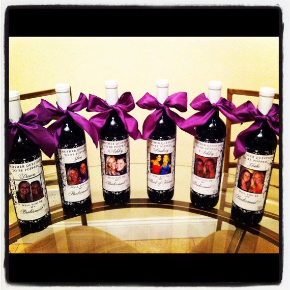 six bottles of wine with purple bows on them sitting on a table in front of a mirror