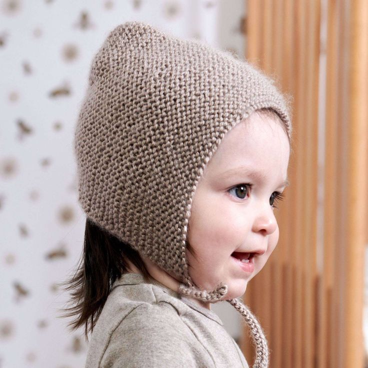 a small child wearing a knitted hat