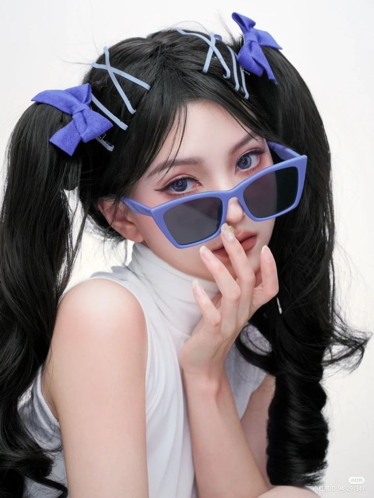 a woman with long black hair wearing blue sunglasses