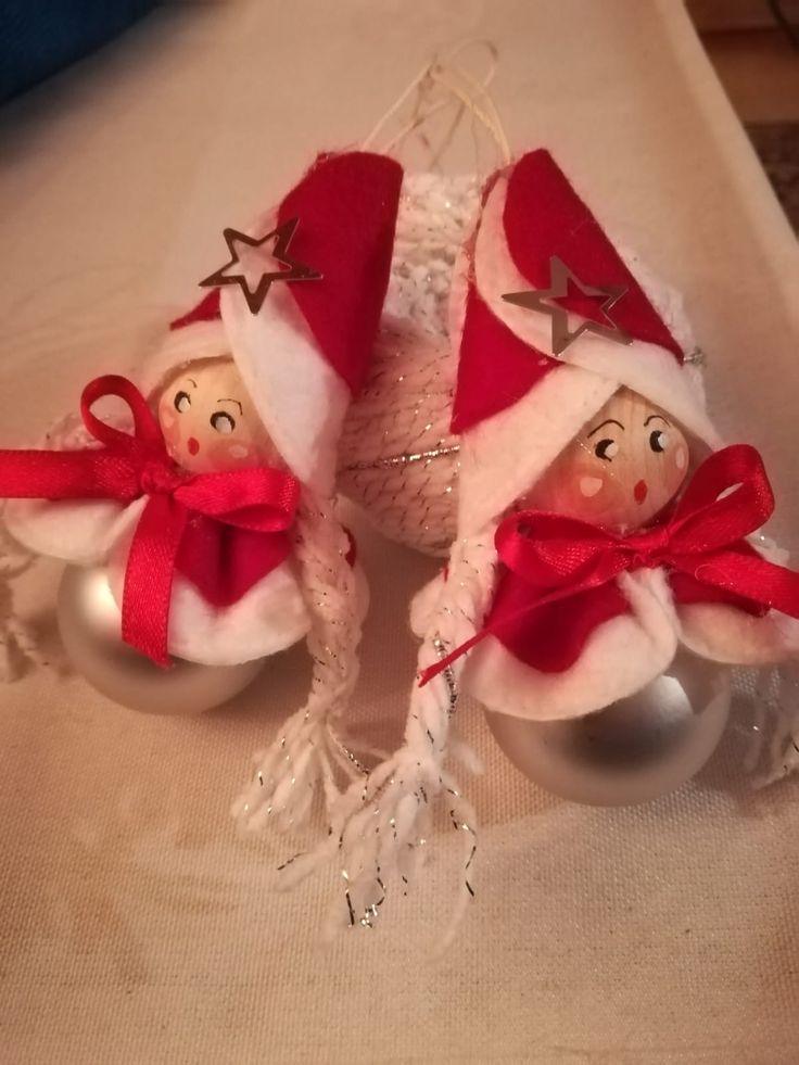 two christmas ornaments are sitting on a table