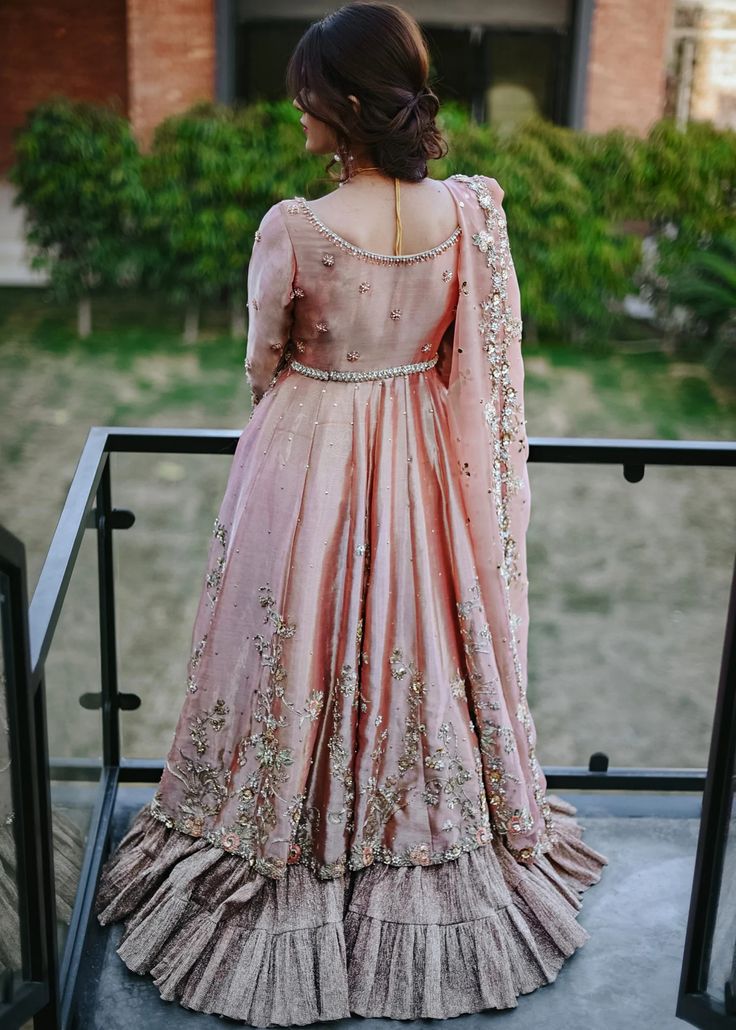 Apricot tissue Pishwas with full sleeves, leaf neck, paired with a matching tissue lehenga. Embrace the elegance of long Anarkali dresses adorned with mirror work and sequins. Perfect for festive events, formal gatherings, and bridesmaids. Elevate your style with Anarkali suits featuring a flared bottom and net sleeves for a captivating look.The tissue fabric apricot pishwas we offer is a creation of exceptional beauty, showcasing the perfect blend of tradition and contemporary design. The apric Frock Lehnga, Design Frock, Nameera By Farooq, Fawad Khan, Walima Dress, Dress Shops, Pakistani Formal Dresses, Wedding Dress Store, Pakistani Wedding Dress