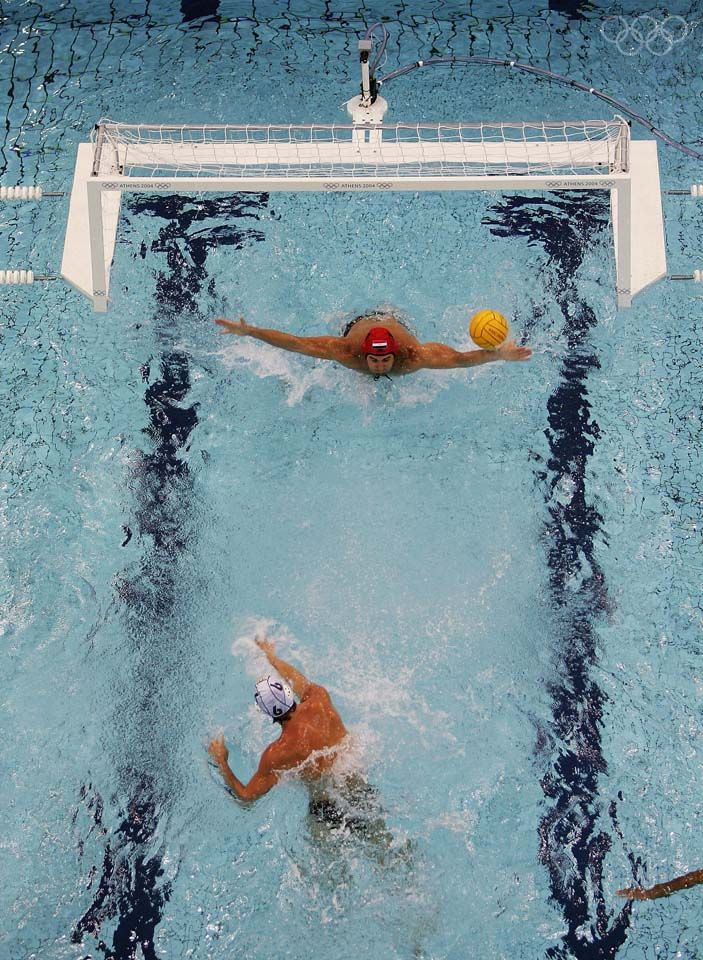 two men are playing water polo in the pool