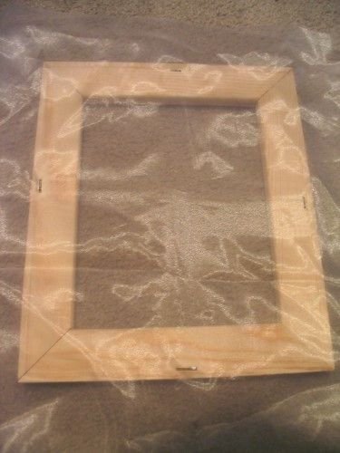 a wooden frame sitting on top of a sheet of plastic