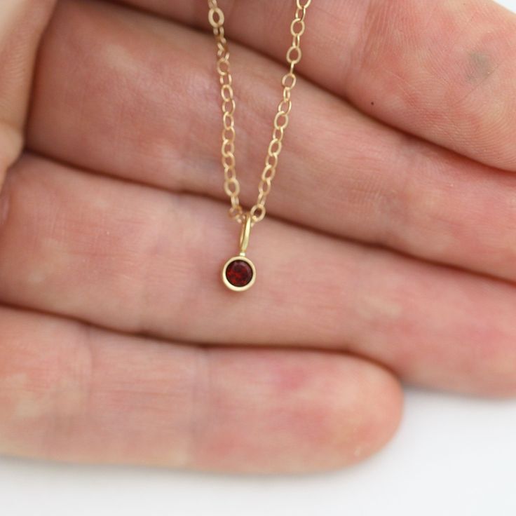 Very classy, simple, and dainty. This handcrafted gold pendant has a natural Garnet stone and comes on your choice of a 16 or an 18 inch gold chain with the artist's tag attached to the clasp. It can also be paired with other pendants! Mix and match to create your own personalized necklace or mother necklace! Gold is 14ky. Stone measures 3mm in diameter. Birthstone for January. All Laine Benthall jewelry comes with a lifetime warranty. This pendant can also be purchased without the chain, just g Recycled Gold Gemstone Birthstone Necklace As A Gift, Recycled Gold Birthstone Gemstone Necklace For Gift, Recycled Gold Birthstone Necklace As Gift, Recycled Gold Birthstone Necklace Gift, Minimalist Tiny Birthstone Necklace As Gift, Tiny Minimalist Birthstone Necklace For Gift, Gold Recycled Gold Birthstone Necklace Gift, Minimalist Gold Birthstone Necklace With Gemstone, Minimalist Recycled Gold Necklace With Birthstone