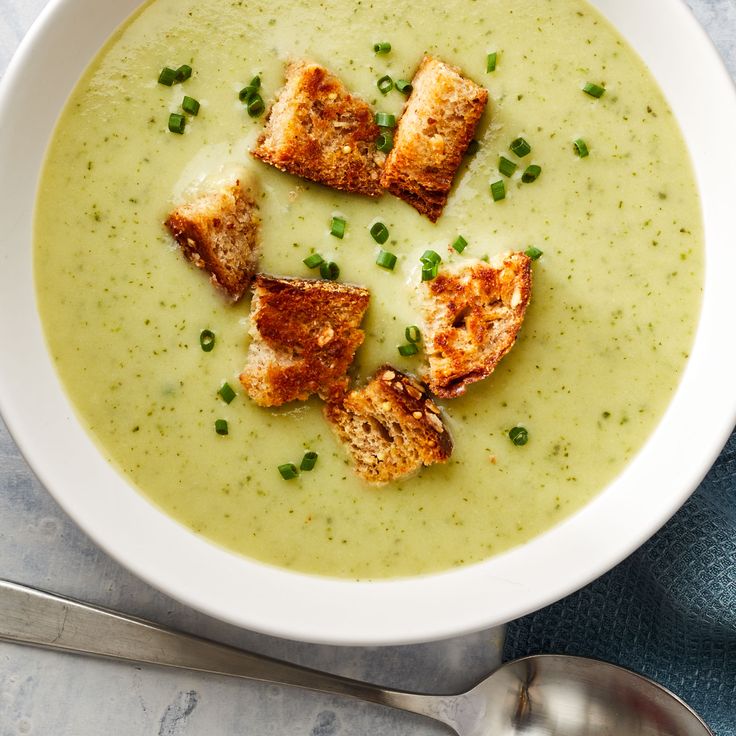 a white bowl filled with soup and croutons