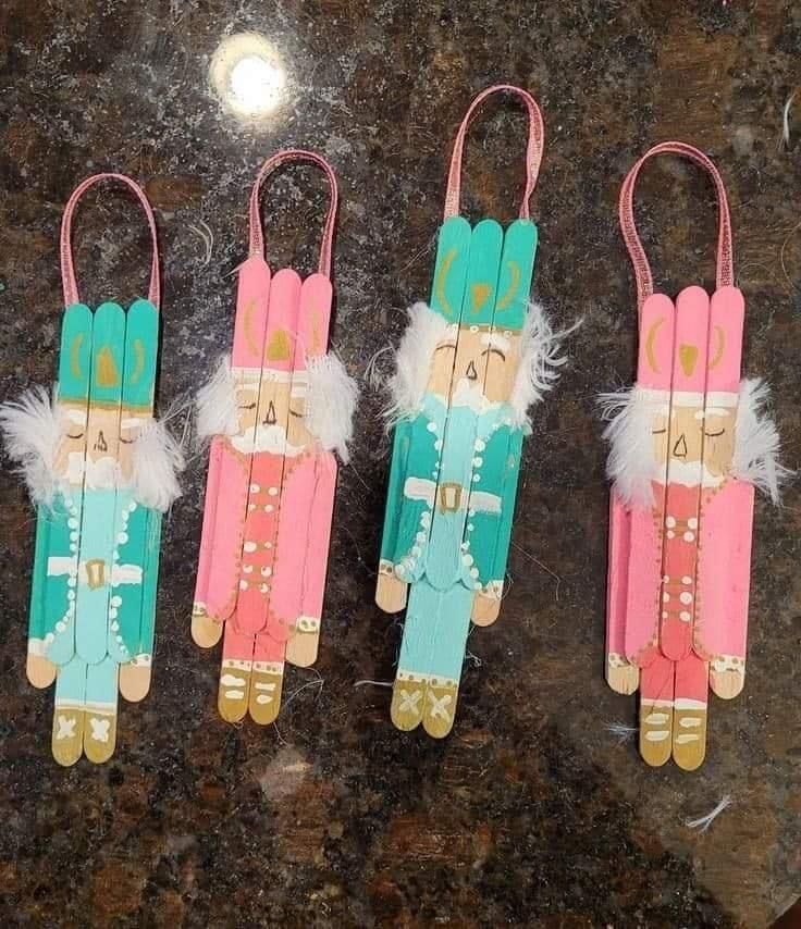 three wooden peg puppets with feathers on them