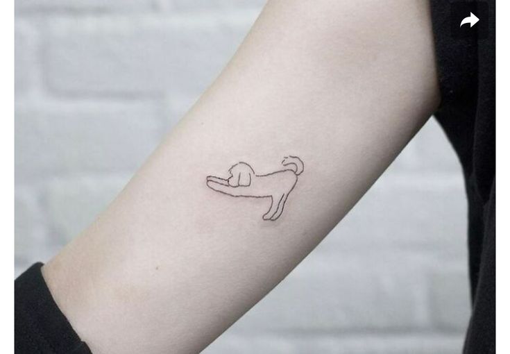 a small dog tattoo on the left inner forearm and arm, which is drawn in black ink