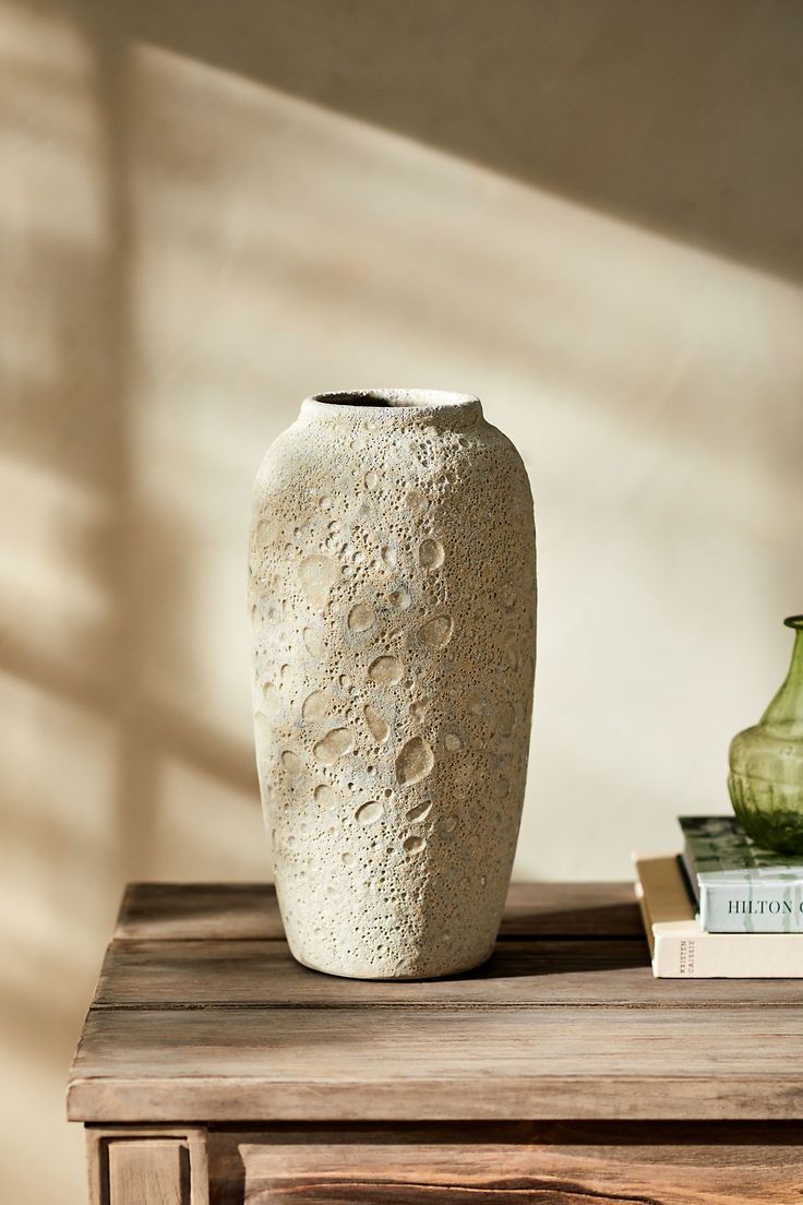 a white vase sitting on top of a wooden table